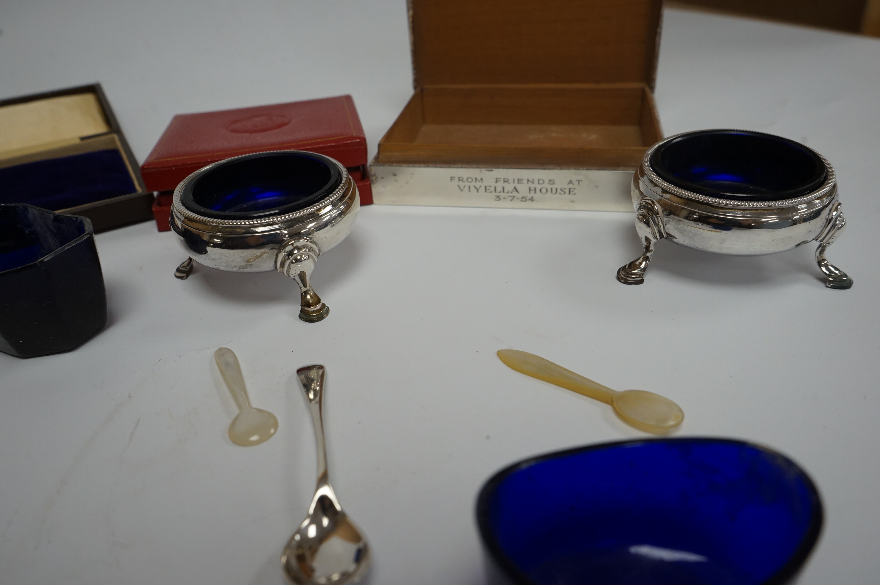 A pair of late George II silver bun salts, David Mowden, London 1759, with blue glass liners, a 1950's silver mounted cigarette box, 11.5cm and seven other items including condiment spoons and a cased Romanian medallion.